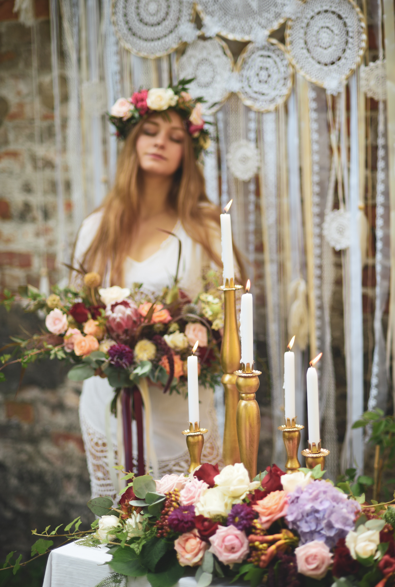 kobieta z wiankiem na głowie i z bukietem w stylu boho na tle łapacza snów oraz kompozycja kwiatowa boho